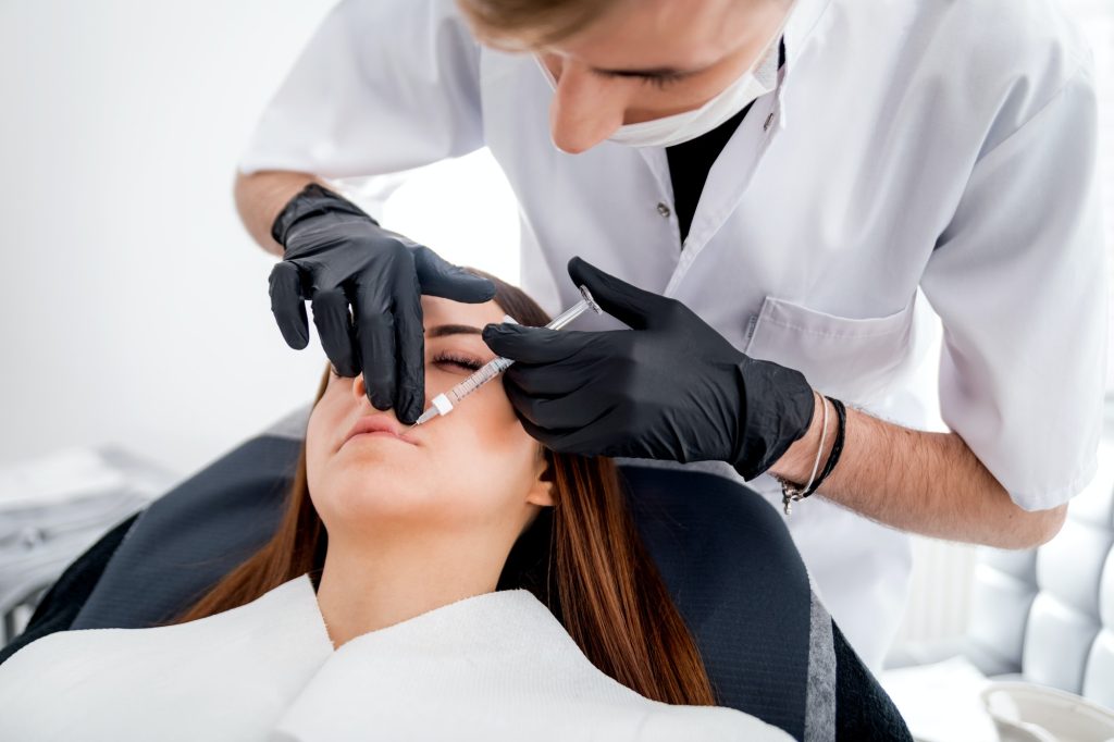 Injectare pentru mărirea buzelor cu seringă, mâini cu mănuși, procedură la Wanderma Clinic