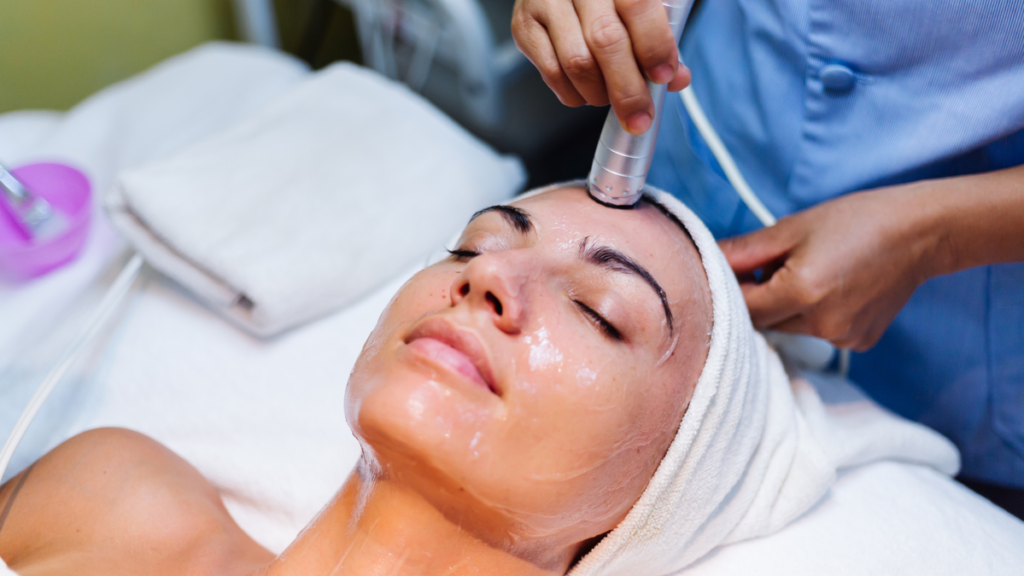 Femeie care primește un tratament facial, cu produs aplicat în zona ochilor, la Wanderma Clinic