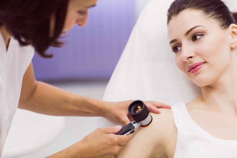 Medic examinând pielea unei paciente cu dermatoscopul la Wanderma Clinic.